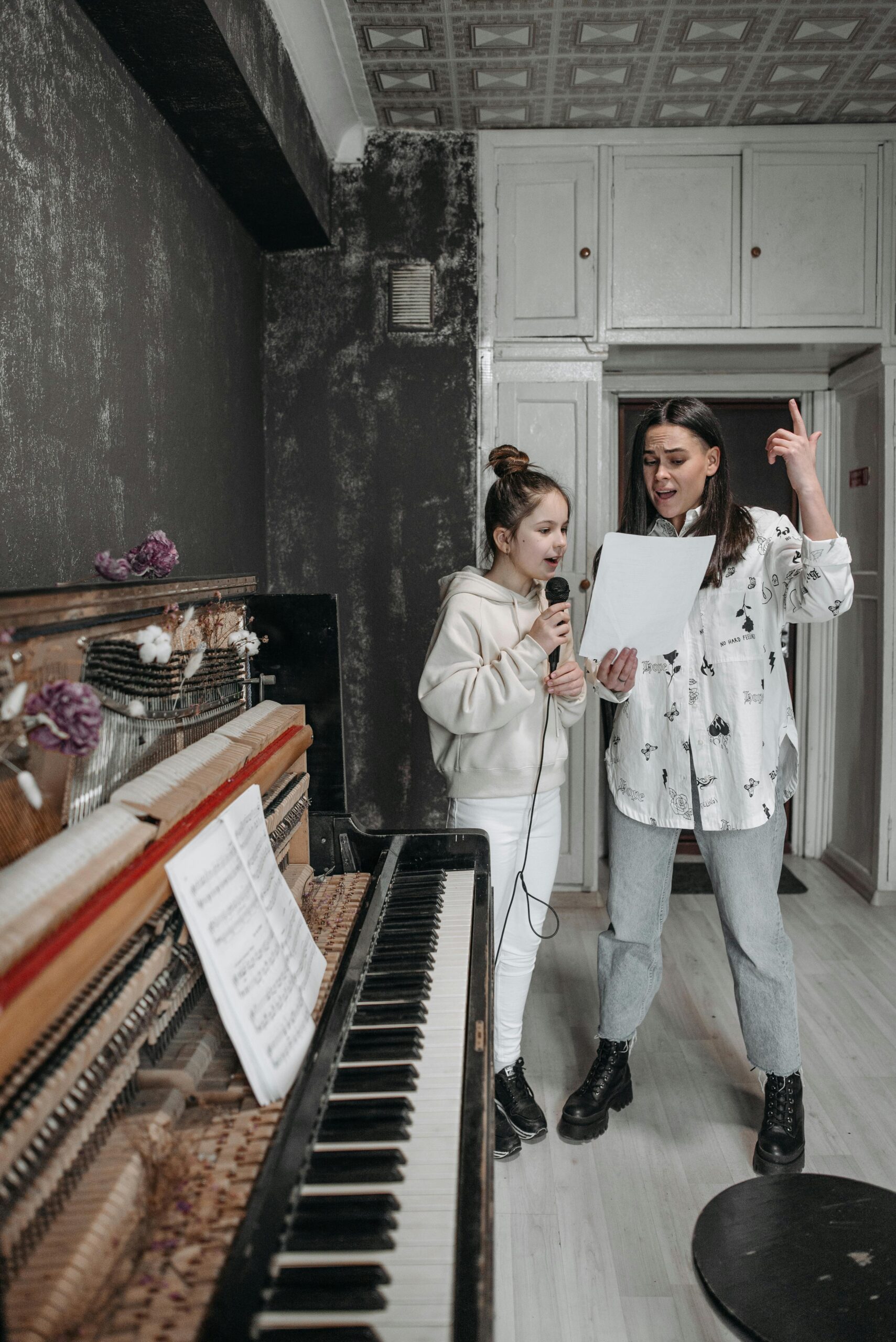 2 Women Standing Beside Piano